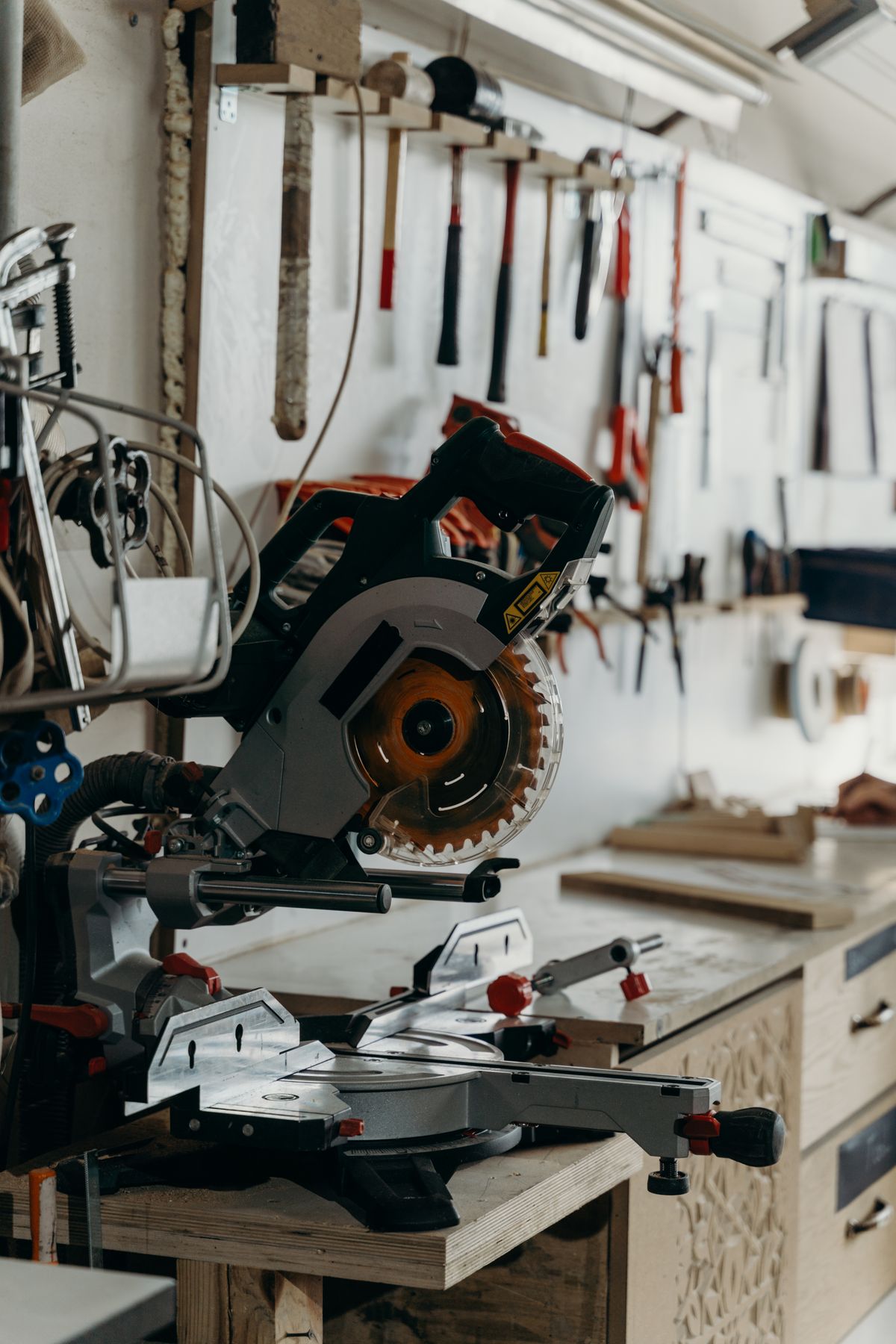 A sliding mitre saw resting on a bench in a woodworking shop